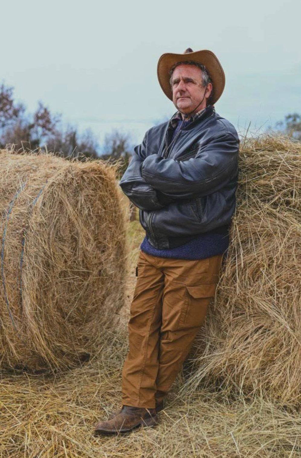 The founder leaning against the hay bales