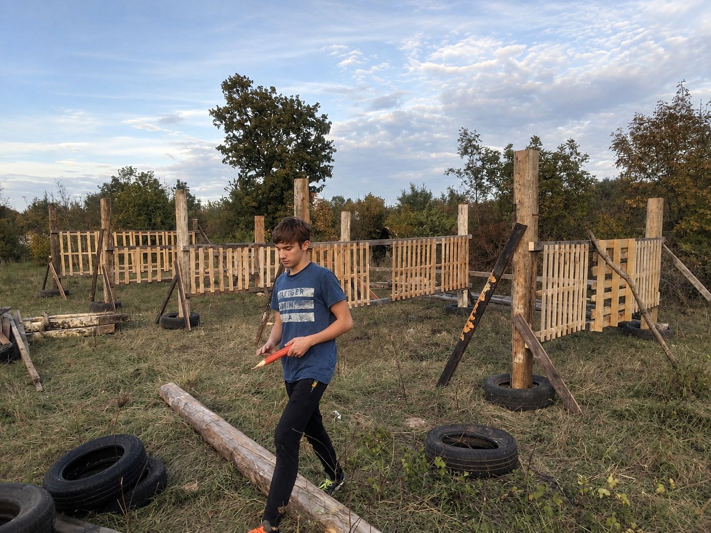 His son Andrej walking through the second ranch while its wooden fences and posts are being built